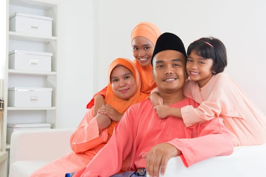 Happy Malay family portrait in traditional clothing during Hari Raya. Malaysian family lifestyle at home.