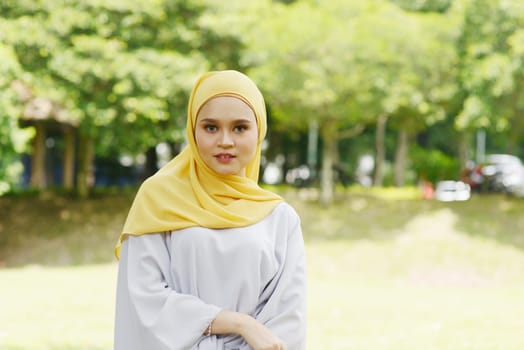 Portrait of cheerful Muslim girl in hijab, smiling at outdoor.