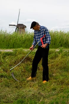 Kinderdijk, Zuid - Holland, The Netherlands - June 9, 2019  Miller mowing the grass in Kinderdijk, the Netherlands..