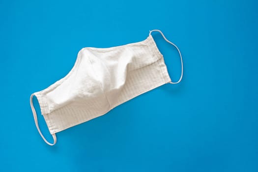 White homemade face mask for adults on a blue background