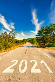 Start of the new year 2021. The number 2021 on a empty Country road in a beautiful landscape. New Year concepts