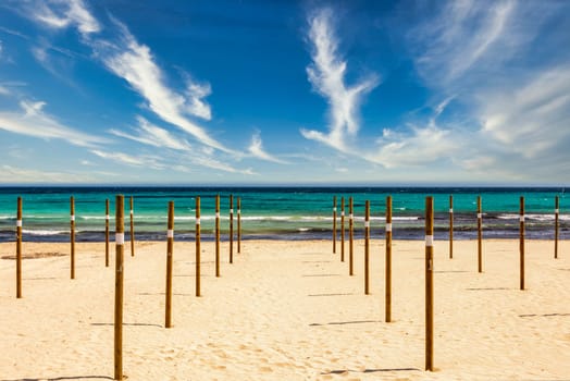 On Sa Coma on the Mediterranean island of Mallorca there are wooden poles in the beach on which the parasols are placed at the start of the season