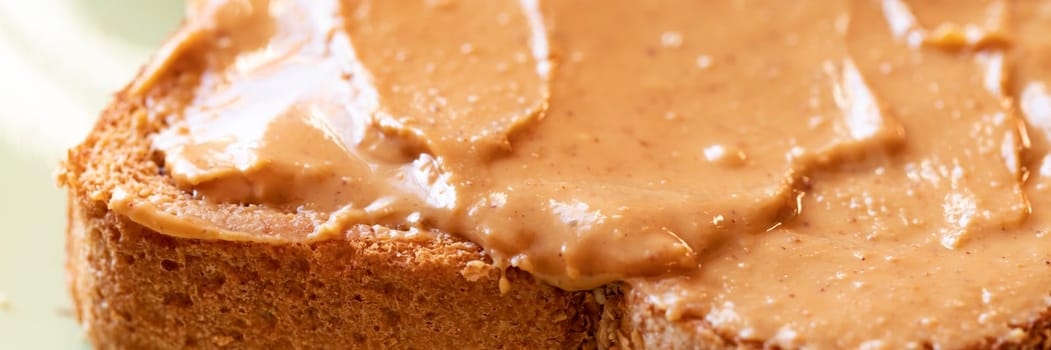 Creamy peanut butter spread on healthy whole wheat toast bread