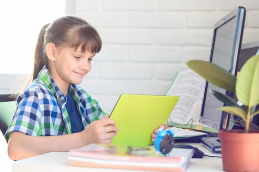 Girl studying at school at home, watching a video lesson online