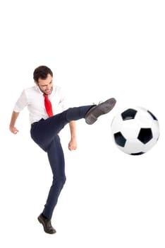 Businessman kicking a soccer ball isolated in white