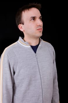 young casual man thinking on black background