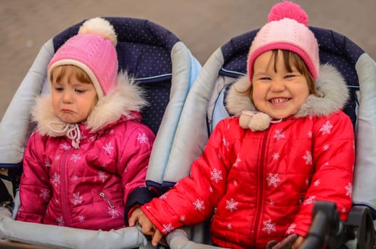 two little girls, sisters. One cries, other laughs