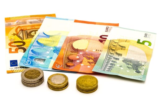 Pile of euro banknotes and coins isolated on white background with clipping path