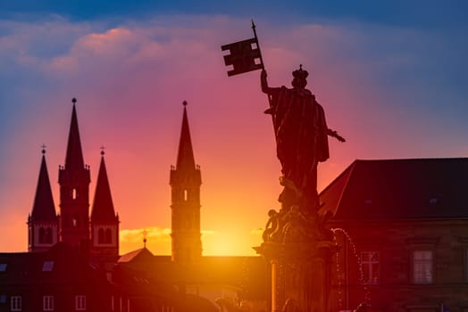 Sunset over city of Wurzburg in Bavaria, Germany. Beautiful sky with sun and clouds in background and old town architecture in foreground