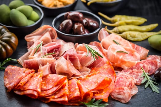 Platter of antipasti with a mixture of salami, prosciutto, chorizo, peppers, tomatoes and olives