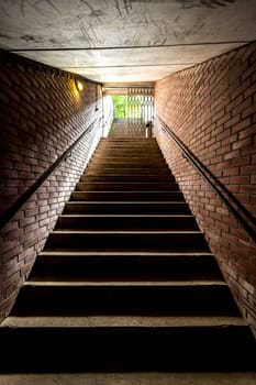 Stairway with a railing that rises from the depths into daylight