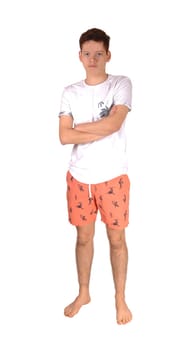 A teenager boy standing bare feet in the studio in his baiding suit with.his arms crossed, isolated for white background.