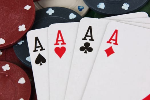 Four aces winning hand on a pile of betting casino chips