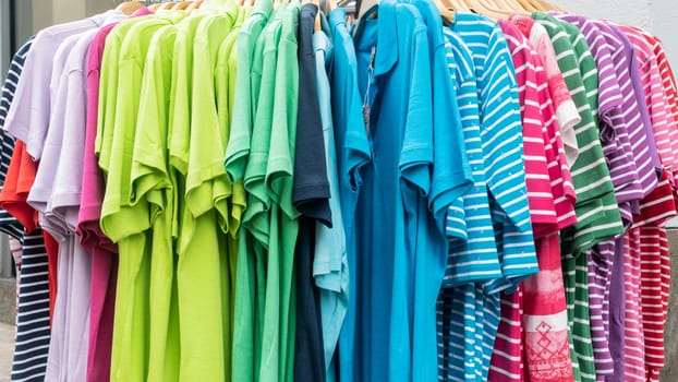 Shop offers colorful clothes in front of a shop