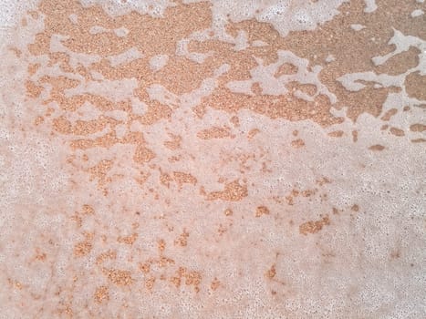 The Mor wave on the coastal sand, the background texture of the sea wave and foam on the sand.