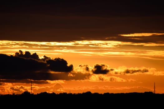 Beautiful orange bright sunset in black clouds.