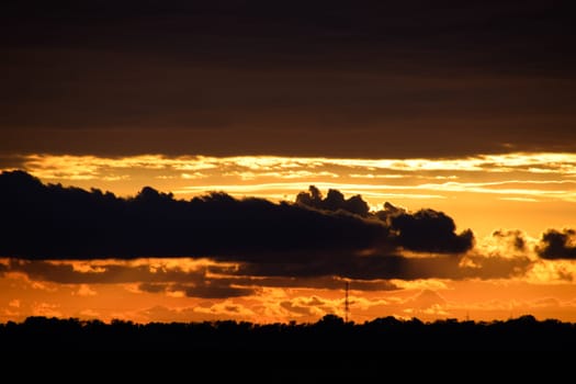 Beautiful orange bright sunset in black clouds.