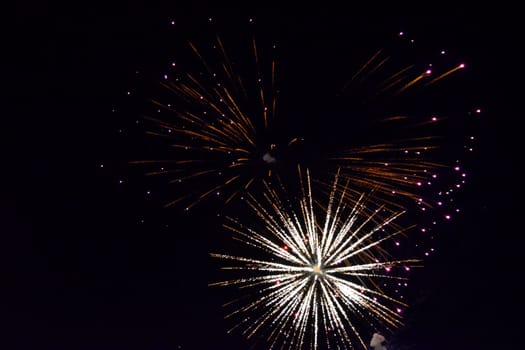 Festive salute in the night sky. Explosions of fireworks and pyrotechnics in the sky.