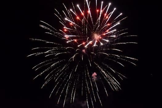 Festive salute in the night sky. Explosions of fireworks and pyrotechnics in the sky.