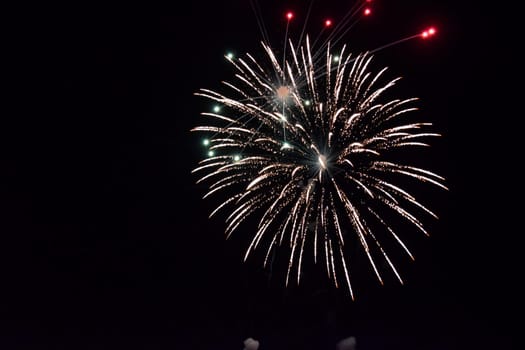 Festive salute in the night sky. Explosions of fireworks and pyrotechnics in the sky.