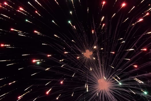 Festive salute in the night sky. Explosions of fireworks and pyrotechnics in the sky.