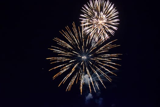 Festive salute in the night sky. Explosions of fireworks and pyrotechnics in the sky.