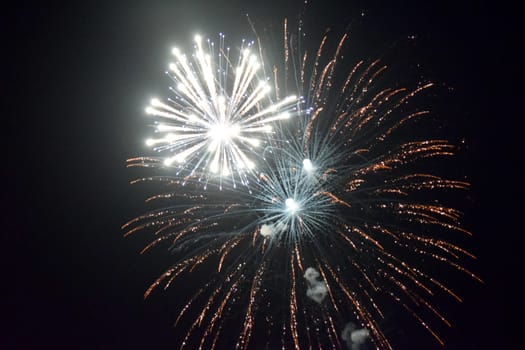 Festive salute in the night sky. Explosions of fireworks and pyrotechnics in the sky.