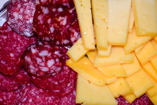 Sausage and cheese on a plate. table setting with sausages and cheeses.