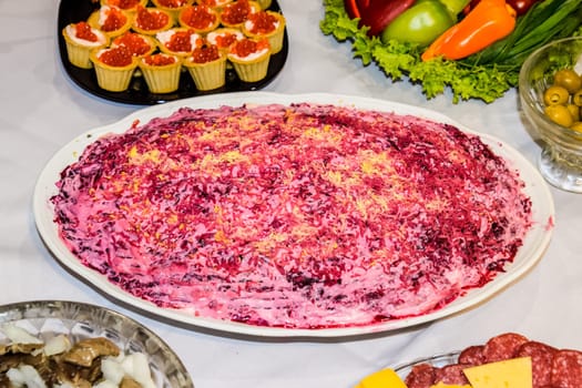 Herring salad under a fur coat. Different dishes on the table