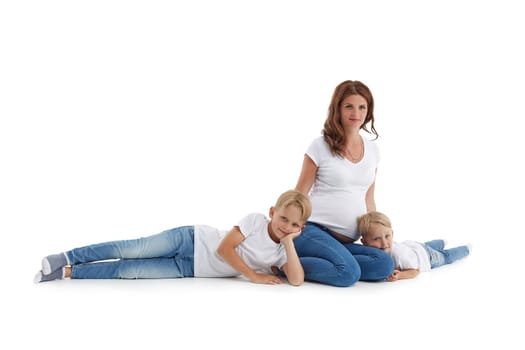 Friendly family. Two little sons are lying near pregnant mother and smiling, isolated on a white background with copy space. Happy parent. Pregnant woman and children. Concept of people and family