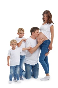 Friendly family. Husband with two sons are smiling and embracing pregnant woman, isolated on a white background.  Happy parents. Pregnant mother and father with children. Concept of people and family