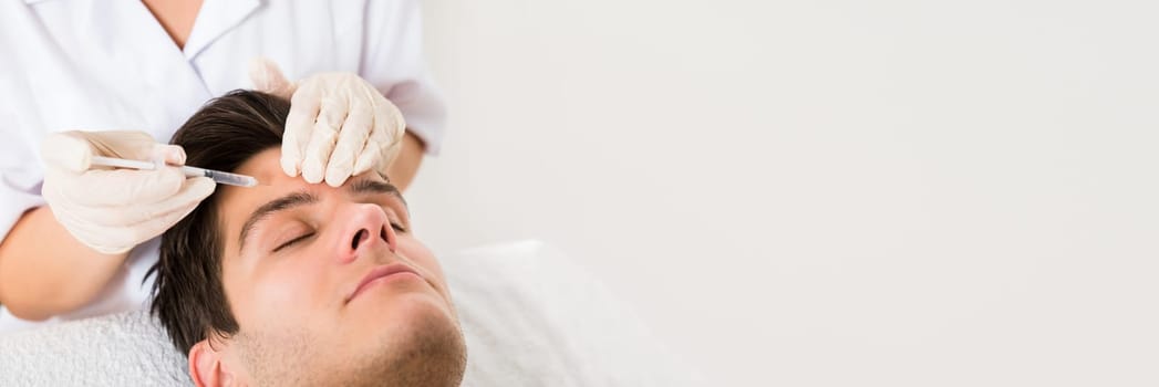 Young Man Having Botox Treatment At Beauty Clinic