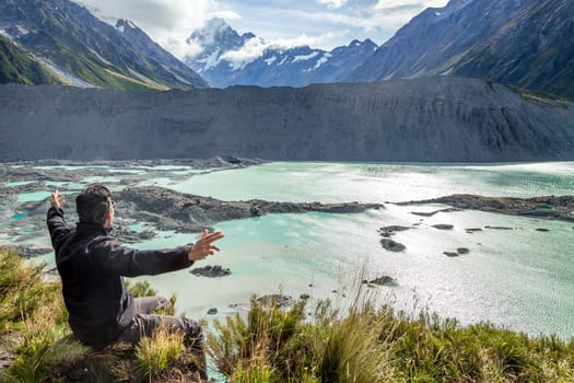 Man with open arms during at Mount Cook, New Zealand ..