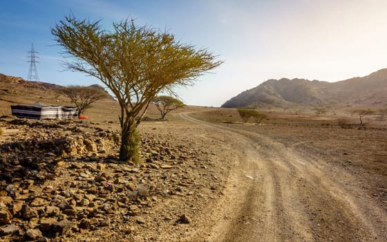 Dirt road in Al Hajar mountains in Fujairah, UAE and a tent