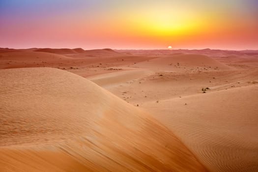 Sun rising over dunes of Dubai Desert Conservation Reserve, UAE