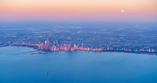 Scenic aerial view of full moon setting over Chicago downtown at sunrise