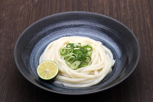 Japanese bukkake udon noodles in a bowl on wooden table