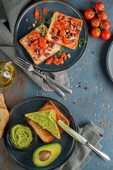 Breakfast served with toast sandwiches with avocado sauce, tomato, onion and herbs.