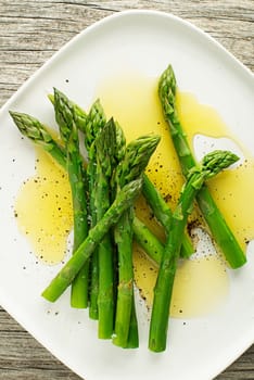 Asparagus. Green asparagus. Fresh boiled Asparagus with dressing on plate close up