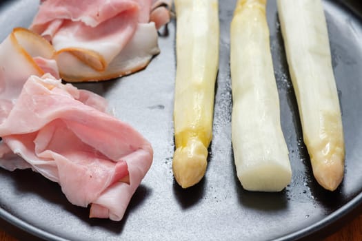 White asparagus with cooked ham close-up