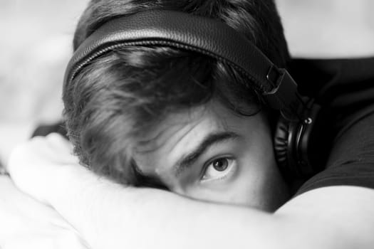 Portrait of young teenage boy with headphones. Black and white photography.