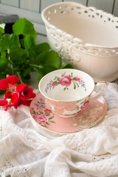 Antique porcelain tea cup on lace table cover, vertical image