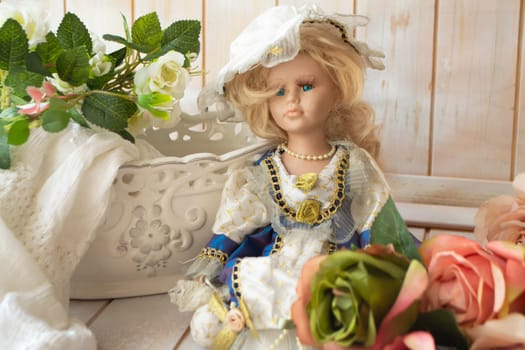 Still life in vintage style with a doll, pastel roses on a shabby background of old wooden planks