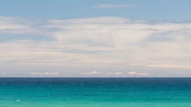 Minimalist seascape with turquoise waters and cloudy sky