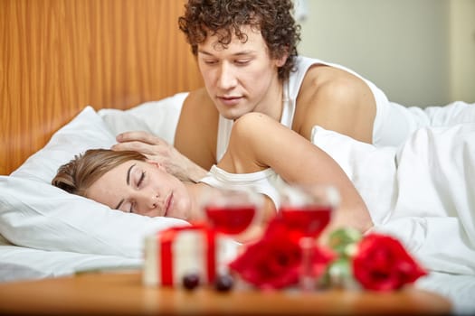 Happy young family sleep in the bed at home. Valentine's Day.