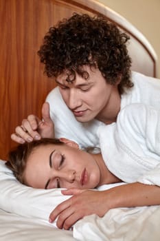 Happy young family  lies in the bed at home.