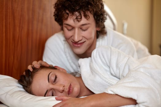 Happy young family  lies in the bed at home.