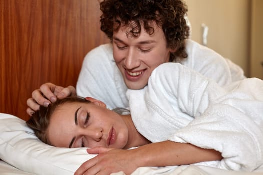 Happy young family  lies in the bed at home.