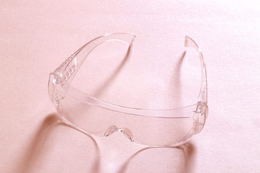 Coronavirus protective measures. Closeup of a clear transparent safety glasses on a black background. Eye protection for infection as part of personal protective equipment. Macro photograph.