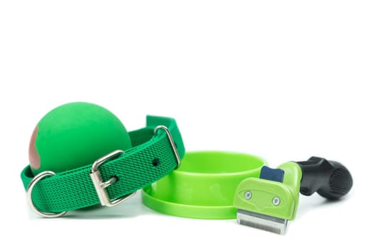 Pet accessories concept.  Bowls, Rubber toy, Collars and brush on isolated white background.